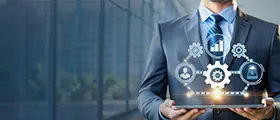 Business professional holding a digital tablet with virtual icons representing data analytics, automation, and digital marketing strategies in a corporate environment.