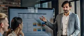 Man presenting project data on a large screen to colleagues.