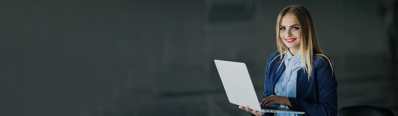 A SAP professional standing with a laptop in hand 