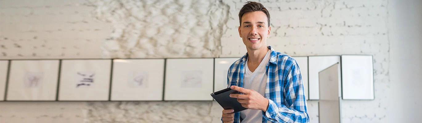Photo of a professional app develper holding a tablet in his hands