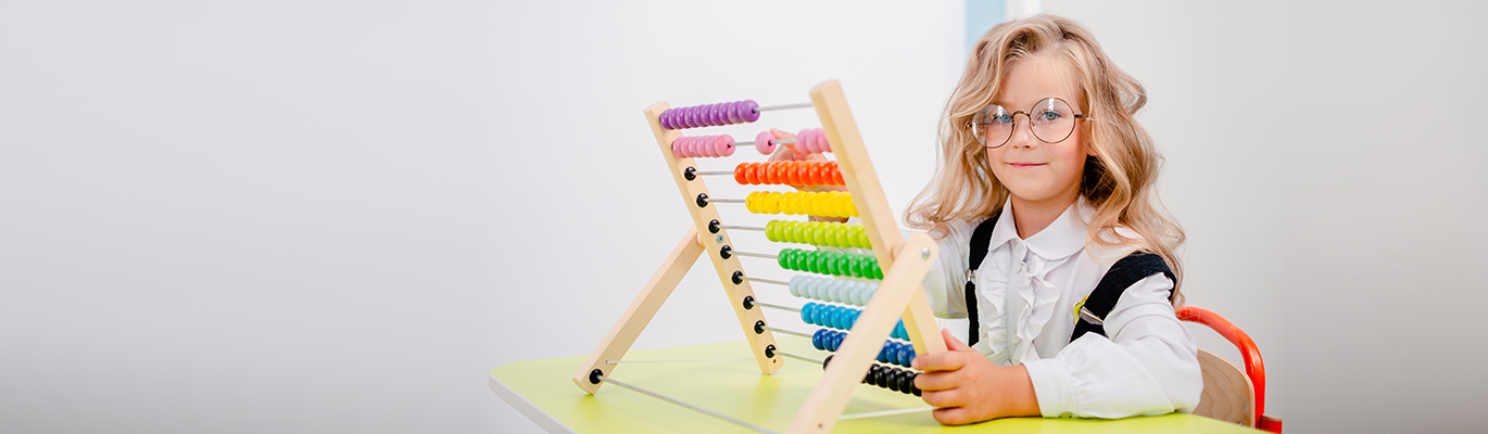 A kid holding abacus and learning about Abacus Classes for Kids