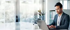 Business professional working on a laptop in a modern office setting