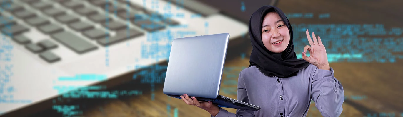 A student wearing a hijab holding a laptop in one hand with a Ok handgesture in other hand
