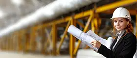 Female engineer with blueprints at construction site