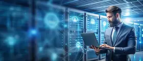 Man in a data center using a laptop surrounded by digital network visuals.