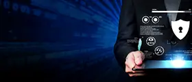 Person in a suit holding a digital tablet with cybersecurity icons and network data overlay on a futuristic blue background.