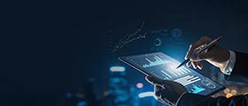 Businessperson using a stylus to analyze data charts on a digital tablet at night.