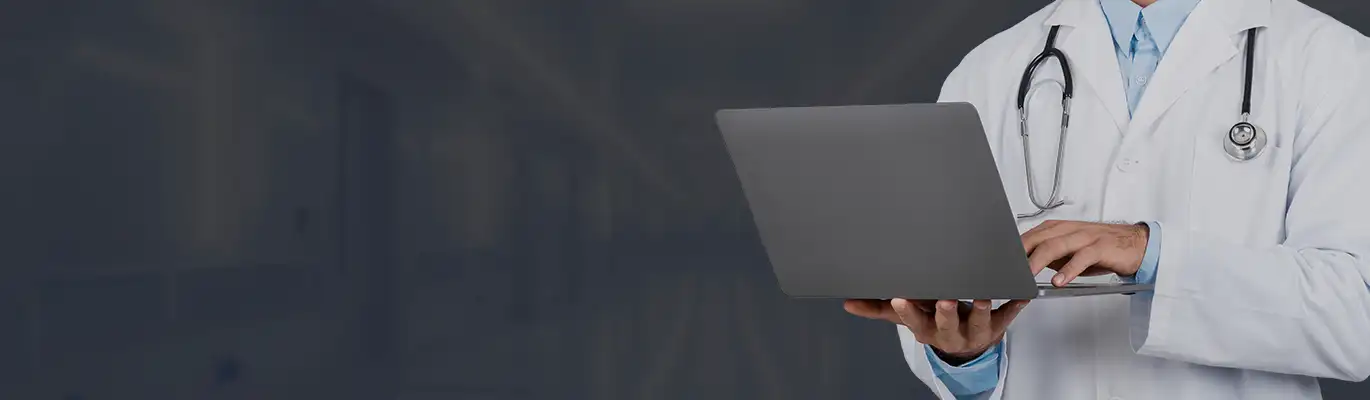 Medical Coder standing holding a laptop on hand