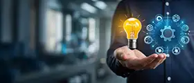 Business professional holding a glowing light bulb and gear icons representing soft skills and innovation.