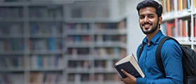 Smiling student with backpack holding books in a library, representing education and learning.