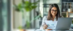 Professional accounting training banner featuring a woman reviewing financial reports and working on a laptop in a modern office environment.