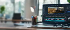 ChatGPT said:  A professional Adobe Premiere Pro video editing workspace showcasing a laptop with an active editing timeline, clips, and effects in a modern office setup.