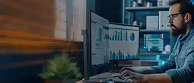 Professional working on Advanced Excel data analysis and reports on dual monitors.