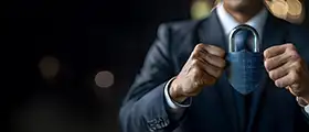 Man in suit holding a large padlock.