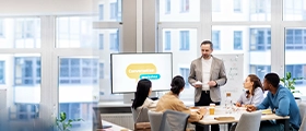 Trainer leading a Certified Training Manager workshop with participants in a modern classroom.