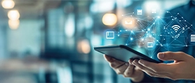 A professional digital transformation training concept showing a business professional holding a smartphone with floating cloud, connectivity, data, and communication icons, representing digital technologies, innovation, and smart business solutions.