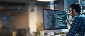 Django developer coding on computer screen in modern workspace.