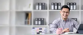 Professional financial accounting specialist working on a tablet at a modern office desk, surrounded by documents and a piggy bank.