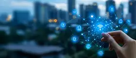 A professional Internet of Things (IoT) concept showing a hand interacting with glowing network icons connected by digital lines against a cityscape background.