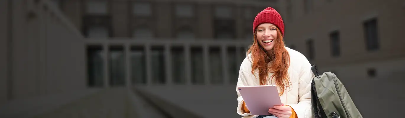 An iPad is held by a language professional while she smiles