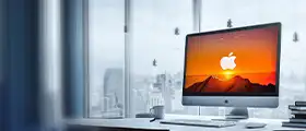 A macOS professional working on an Apple iMac in a modern office environment