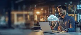 Cloud technology expert analyzing data on a laptop with virtual cloud and network graphics displayed