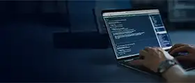 Person coding on a laptop with a software development interface displayed on the screen, representing programming, coding, and software development training.