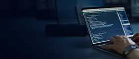 A professional programming specialist working on secure code and cybersecurity systems on a laptop