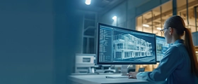 Professional engineer working on RISA 3D software, analyzing structural building model design on a desktop monitor in a modern office setting