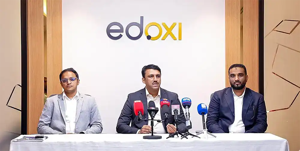 Sharafudhin Mangalad, CEO of Edoxi Training Center at press conference table with microphones, in front of Edoxi branding.